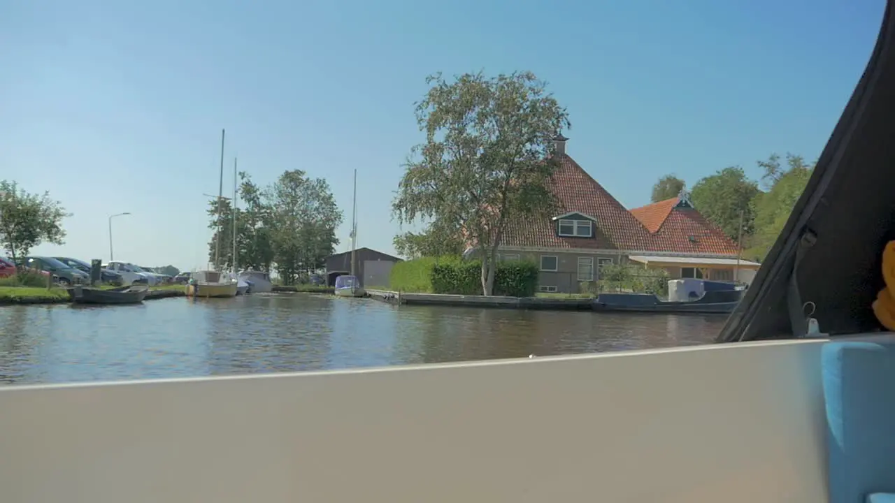 Sailing past a Monumental Farmbuilding with a boat in the summer