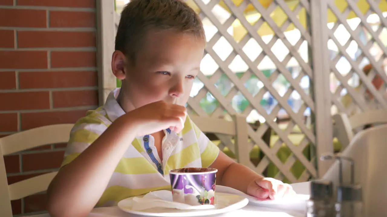 Child eating chocolate ice cream in cafe