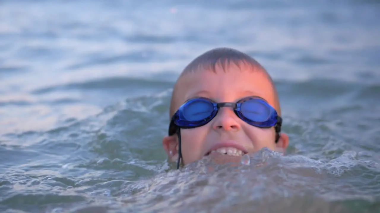 Cheerful boy in goggles bathing in the sea