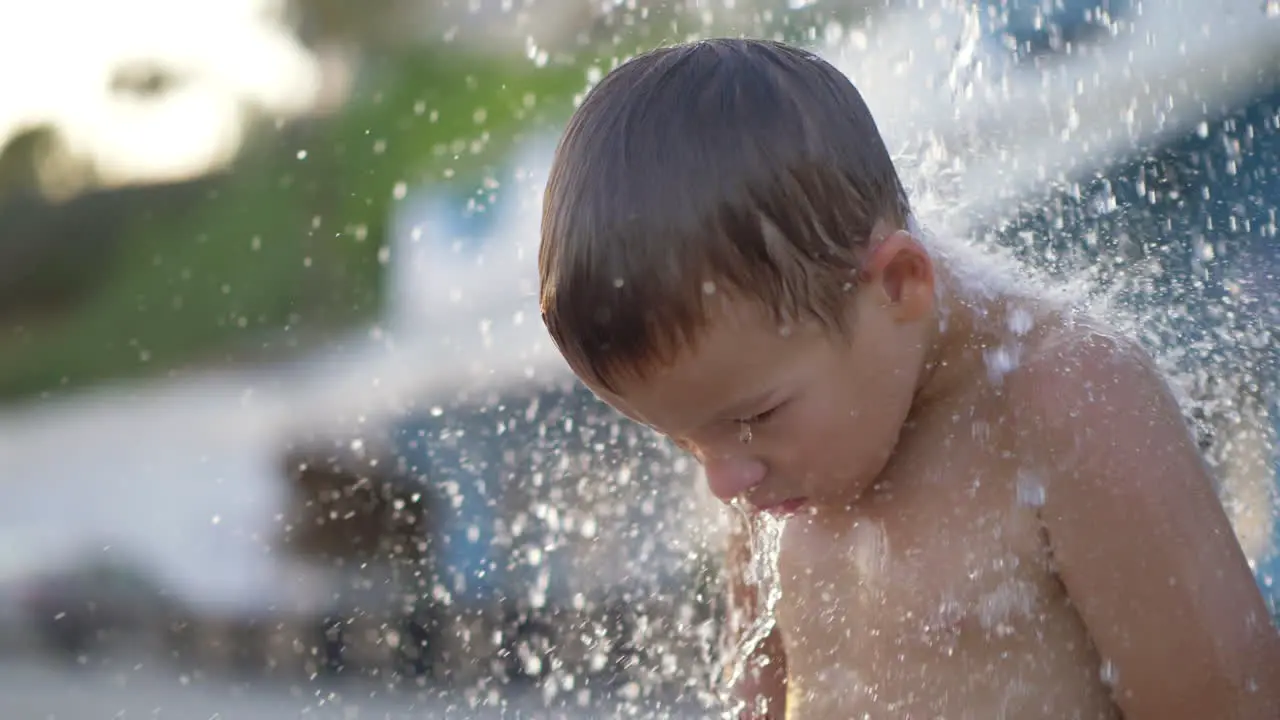 Child taking outdoor beach shower after bathing in sea