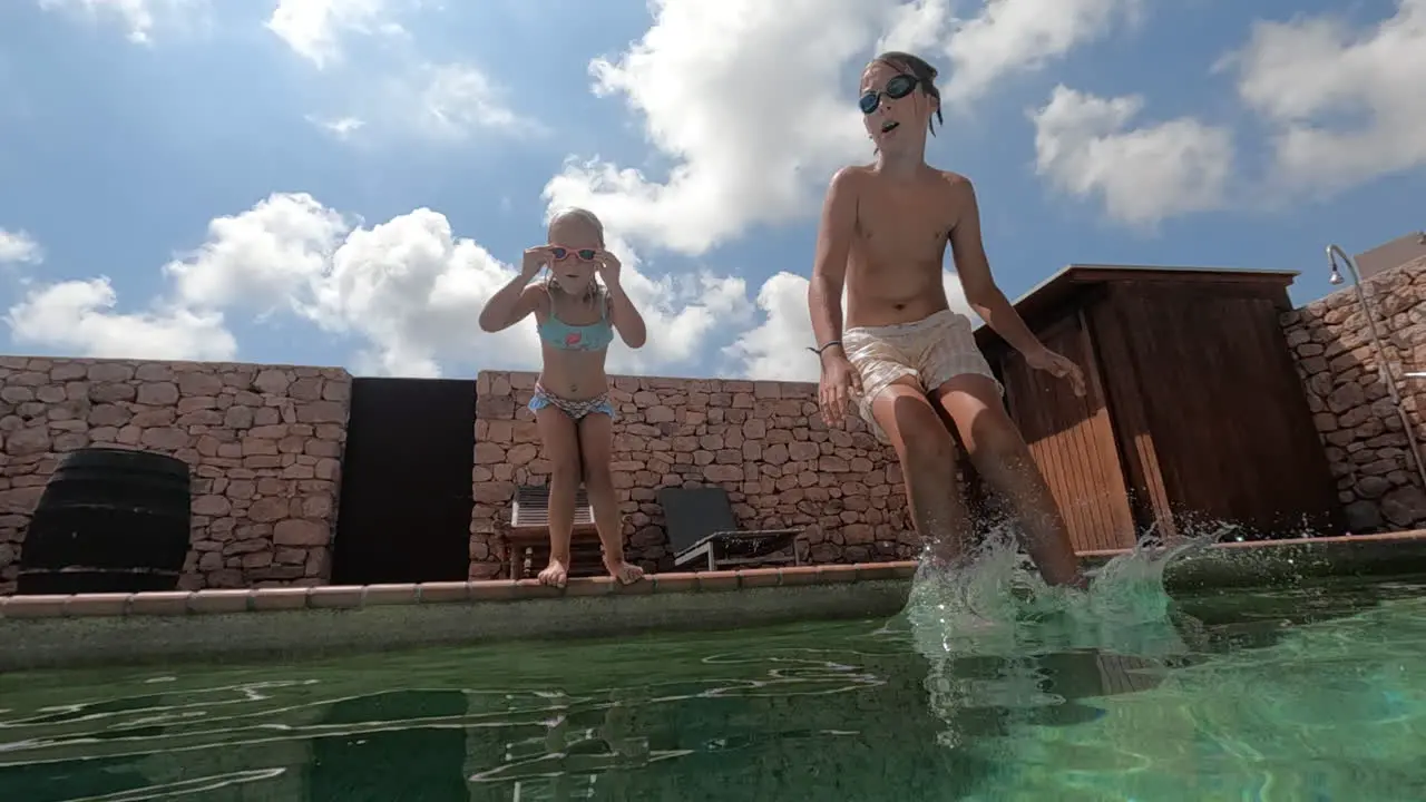 Slow motion children dive into the outdoor pool