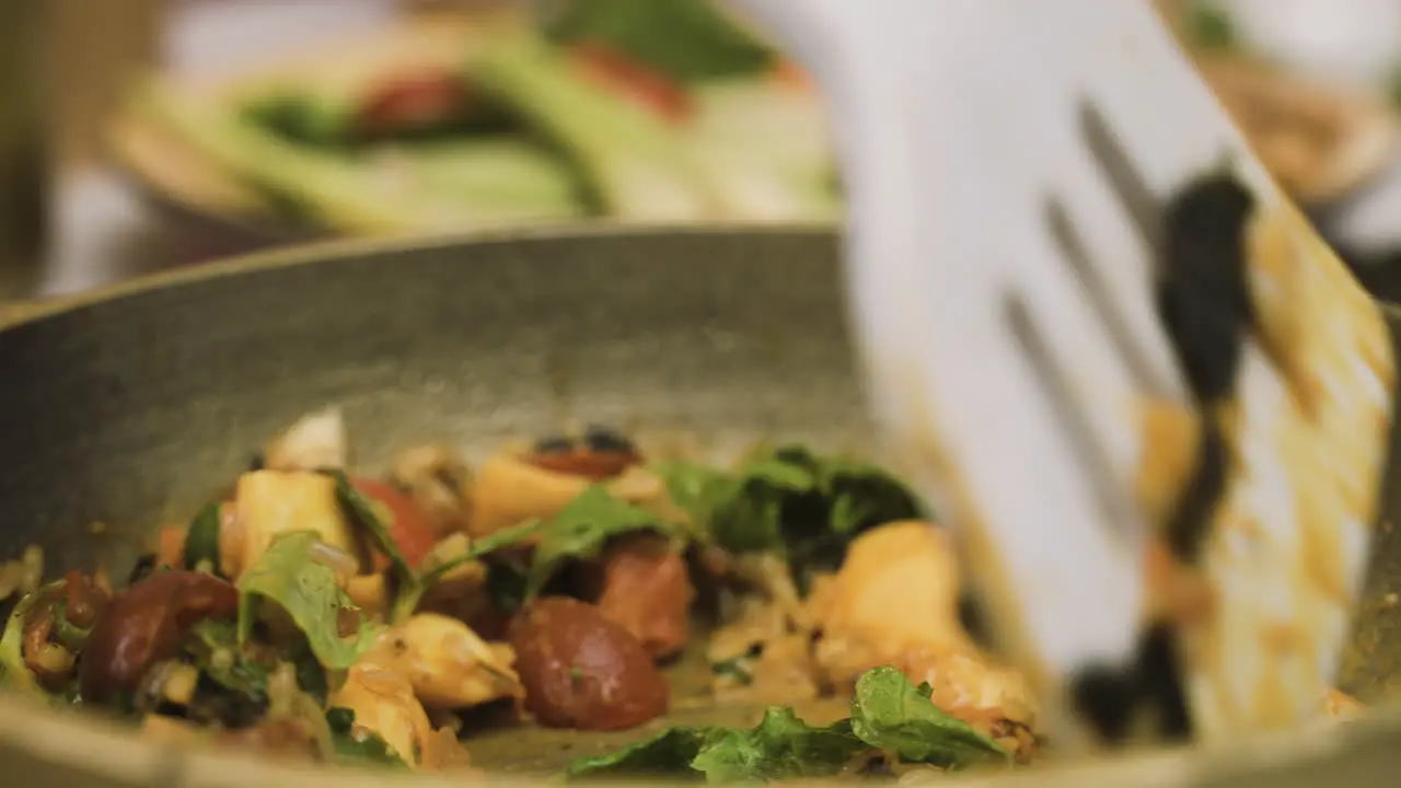 Close Up View Of Japanese Food In The Pan While The Cook Moves It With A Slotted Spatula 1