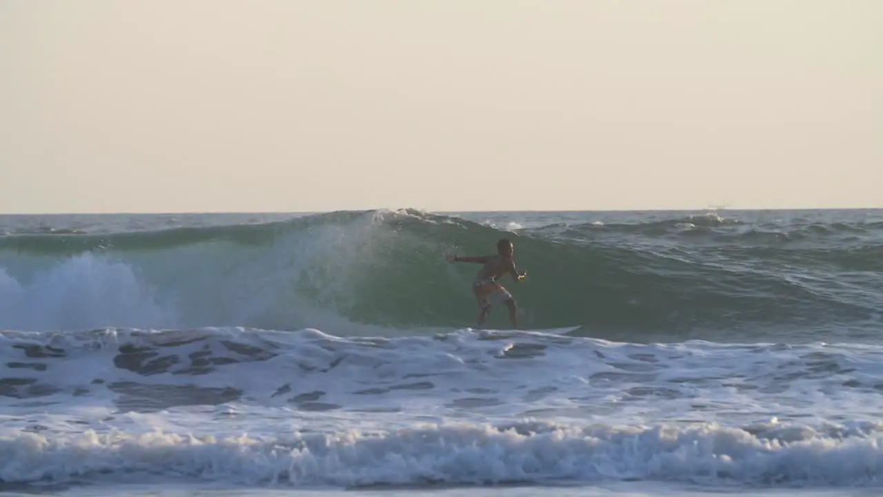 Man Surfing and Gripping his Surfboard