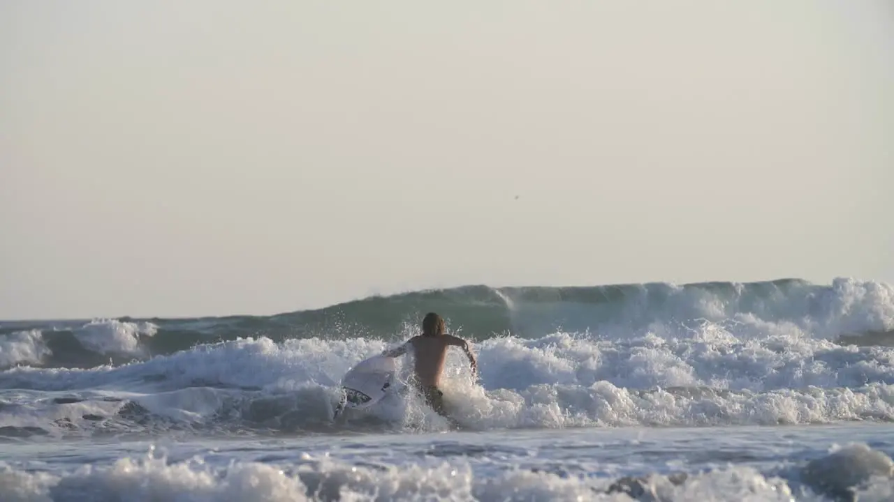 Surfer Walking Through Large Waves