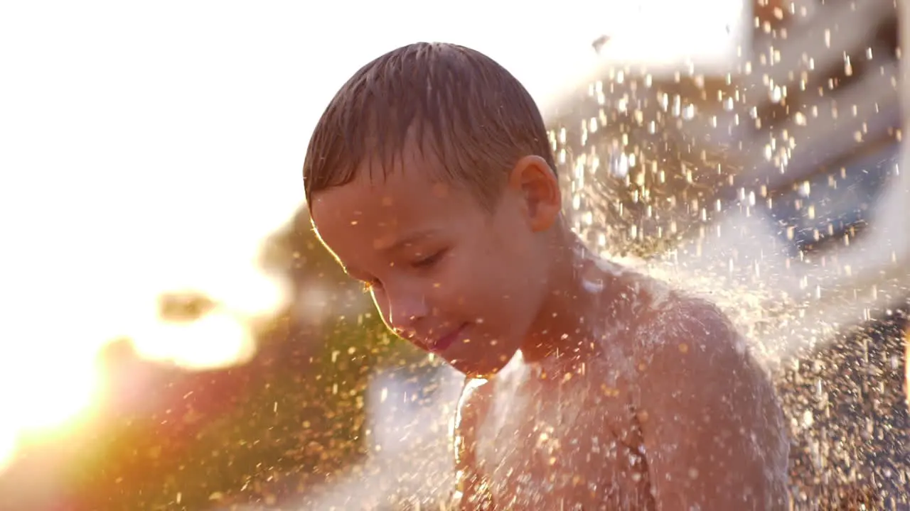 Child taking beach shower at sunset