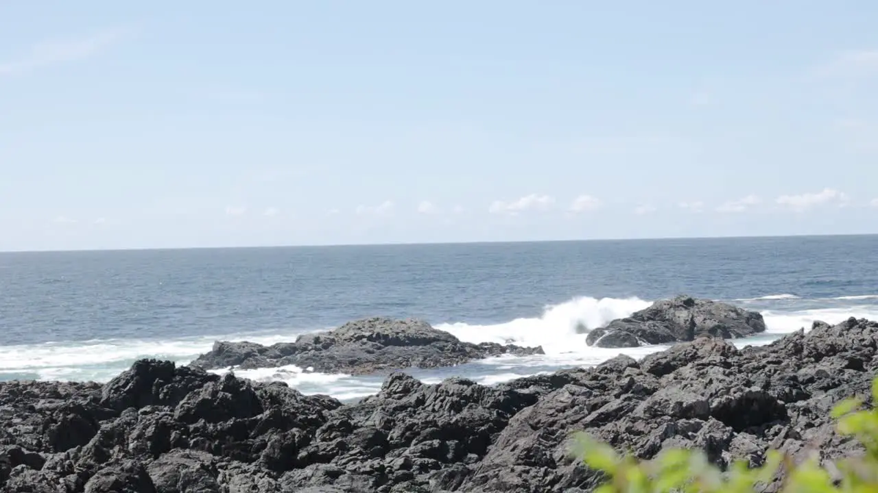 A slow motion handheld video of waves crashing against the rocks on the ocean coast