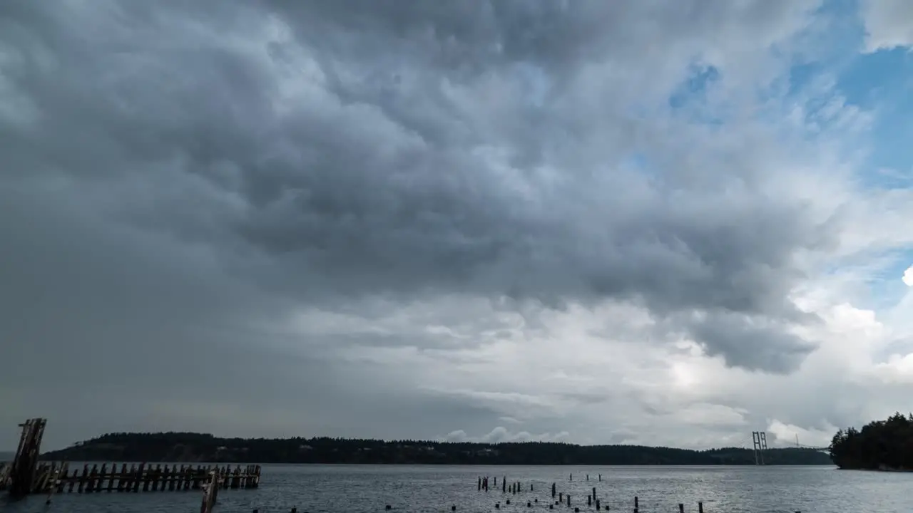 Panning left to right and zoom out Time lapse of a storm system moving north over Puget Sound and the Tacoma Narrows Bridge