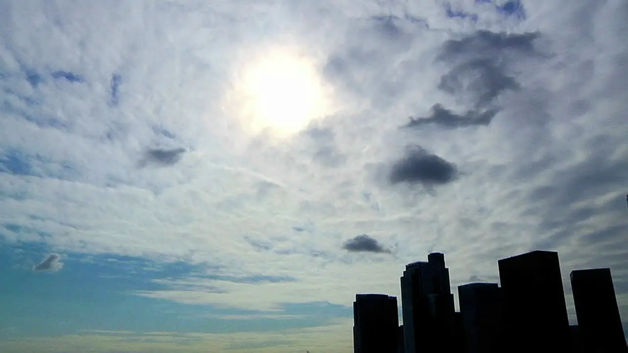 Time lapse of clouds passing over an urban skyline in silhouette 