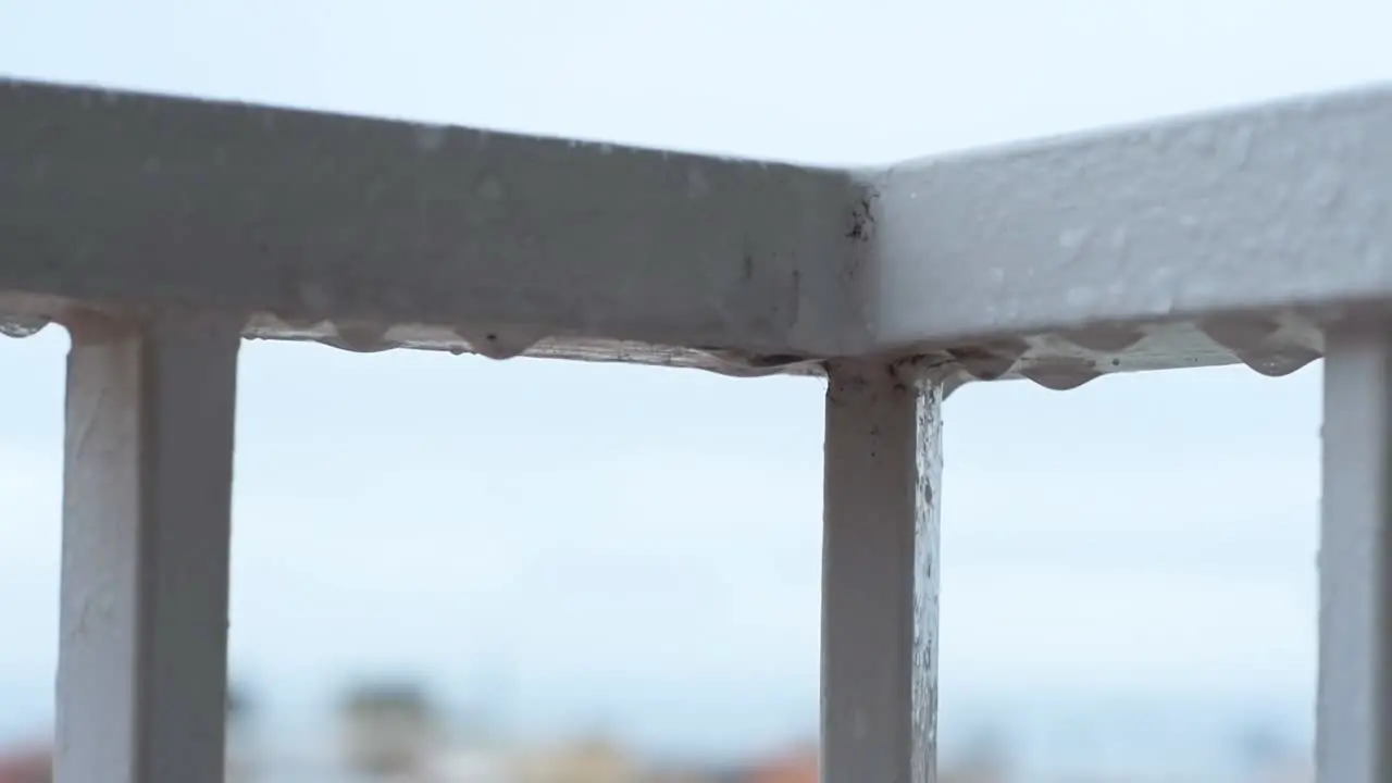 Raindrops on the balcony railing falling while it rains