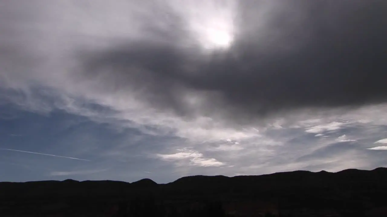 Long shot of sunlight shining through storm clouds