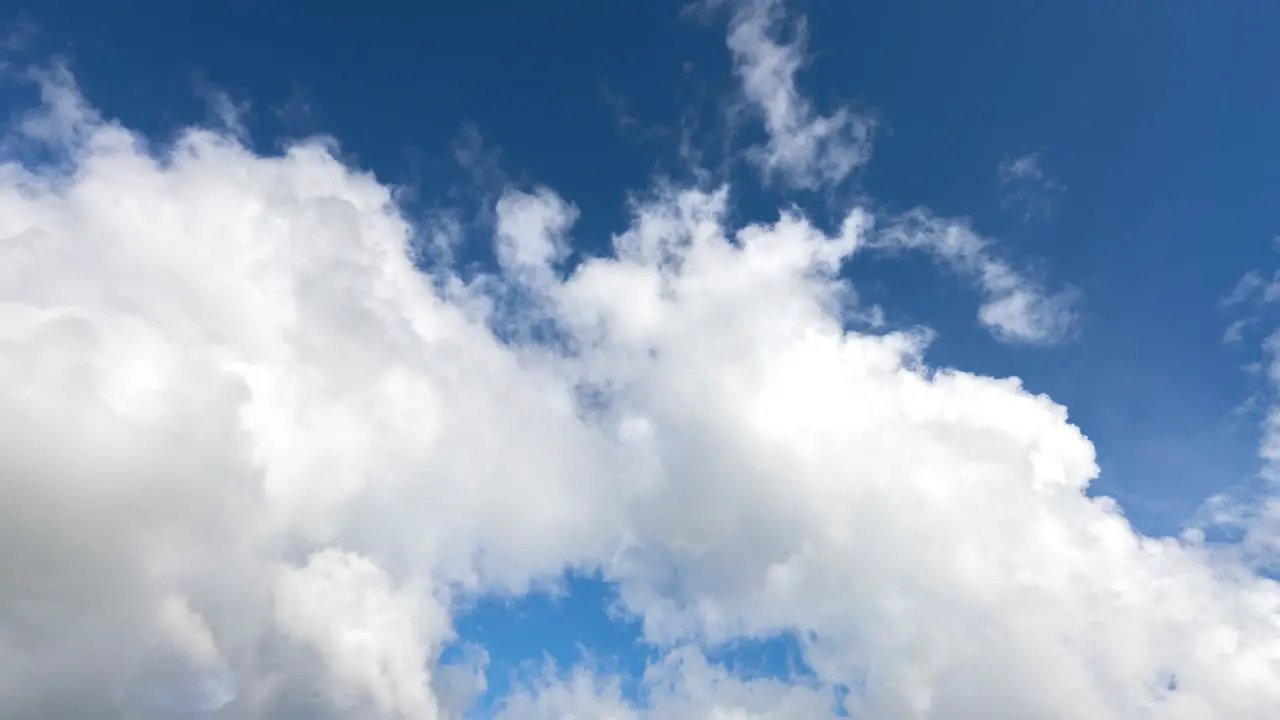 Time lapse of white clouds being blown away revealing the bright blue sky