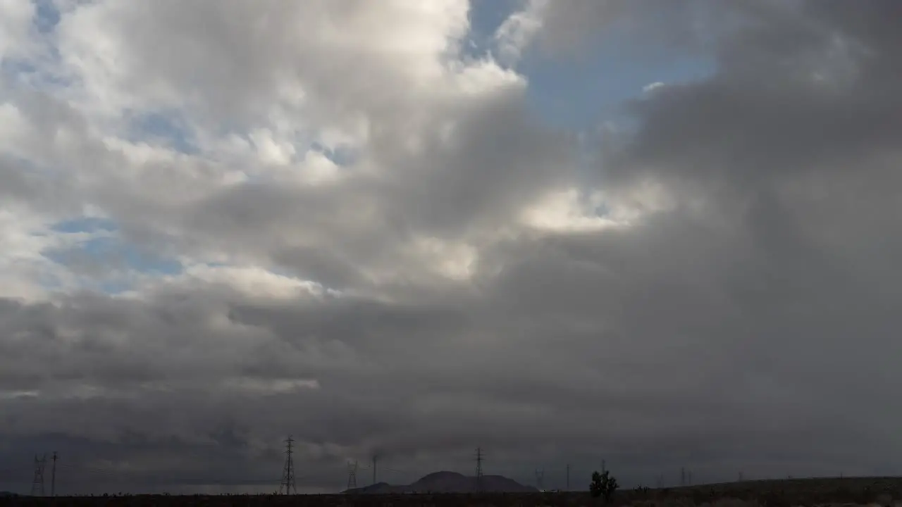 Cloudscape over the Mojave Desert landscape mountains and electrical transmission towers static wide angle time lapse