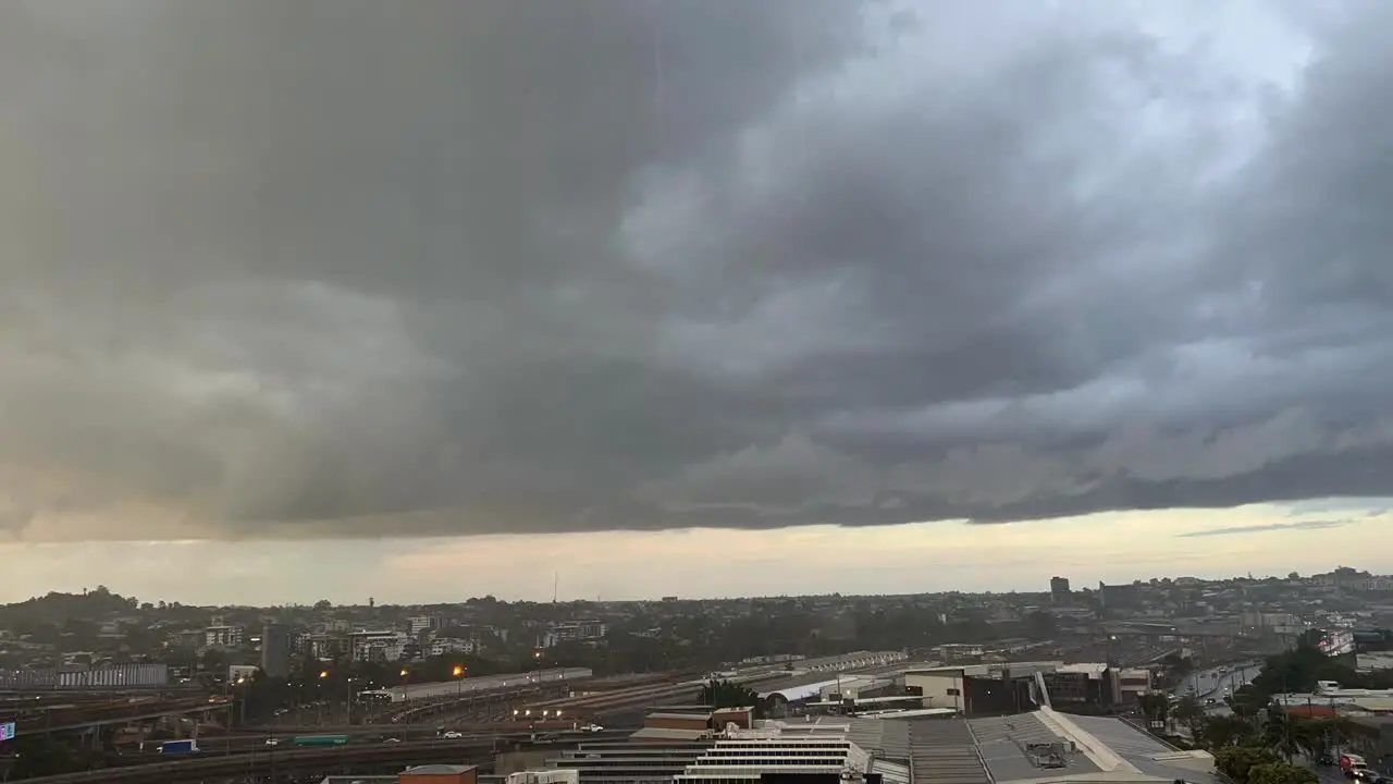 Dramatic time-lapse shot capturing dark and dense rainstorm clouds accumulating and forming in the sky and sudden flash heavy rain across Brisbane city Queensland Australia