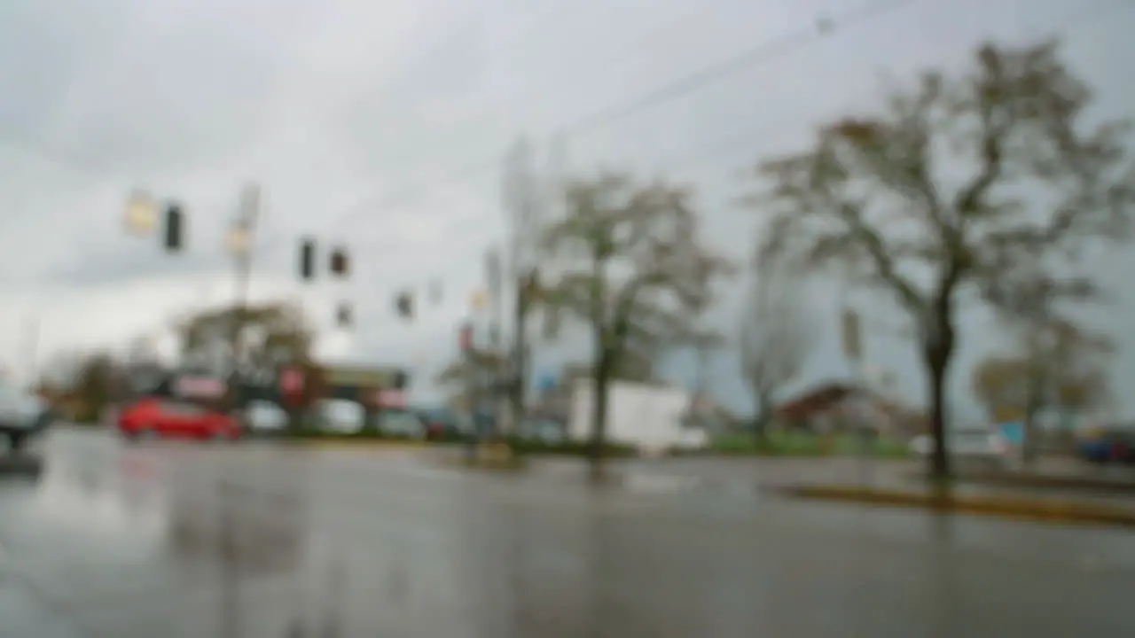 Defocused White Van Turn From Corner On Wet Asphalt City Road Intersection Under Gloomy Sky