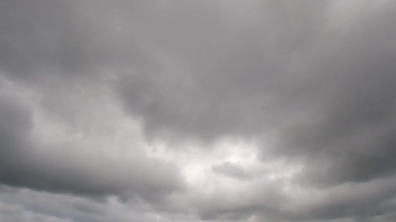 Static timelapse of white and grey clouds rolling through the sky