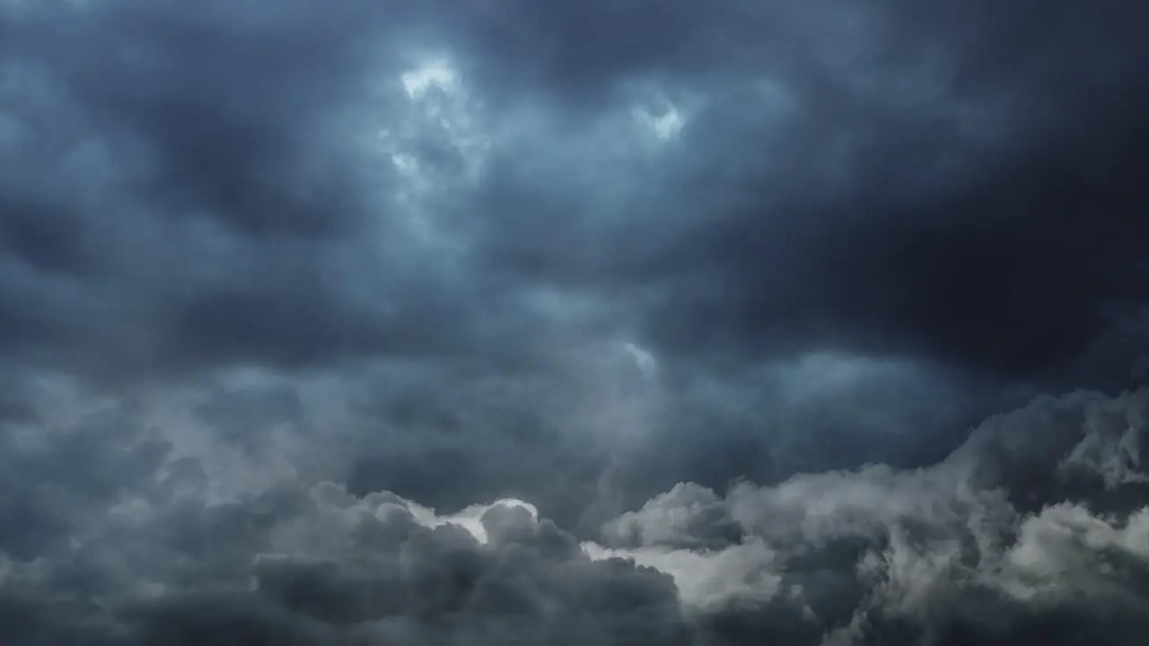 clouds gradually brightening in a dark sky with occasional lightning strikes