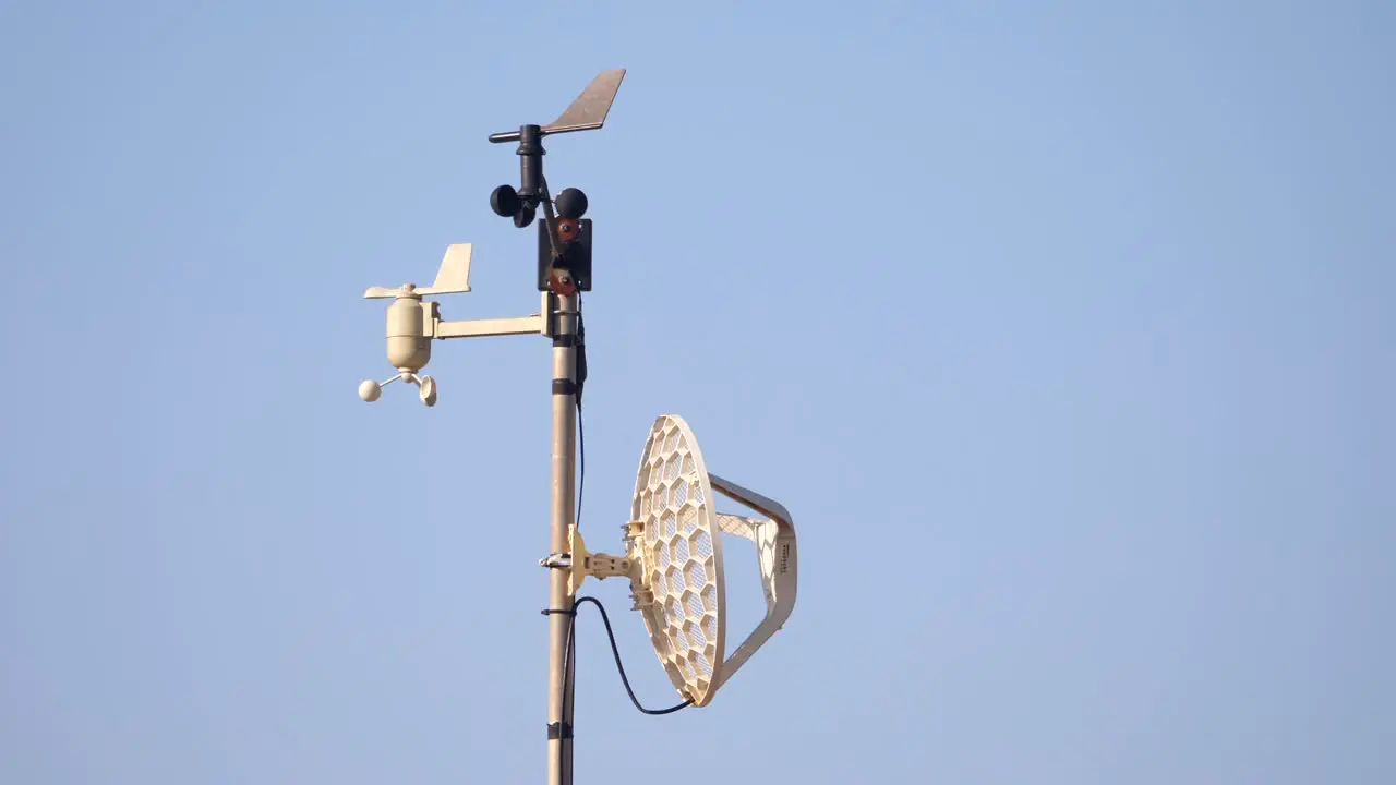 Home weather station spins in the wind against a blue sky background