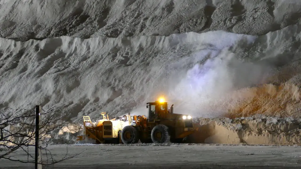 Snowblower at night shift Blowing the Snow in to a Mountin