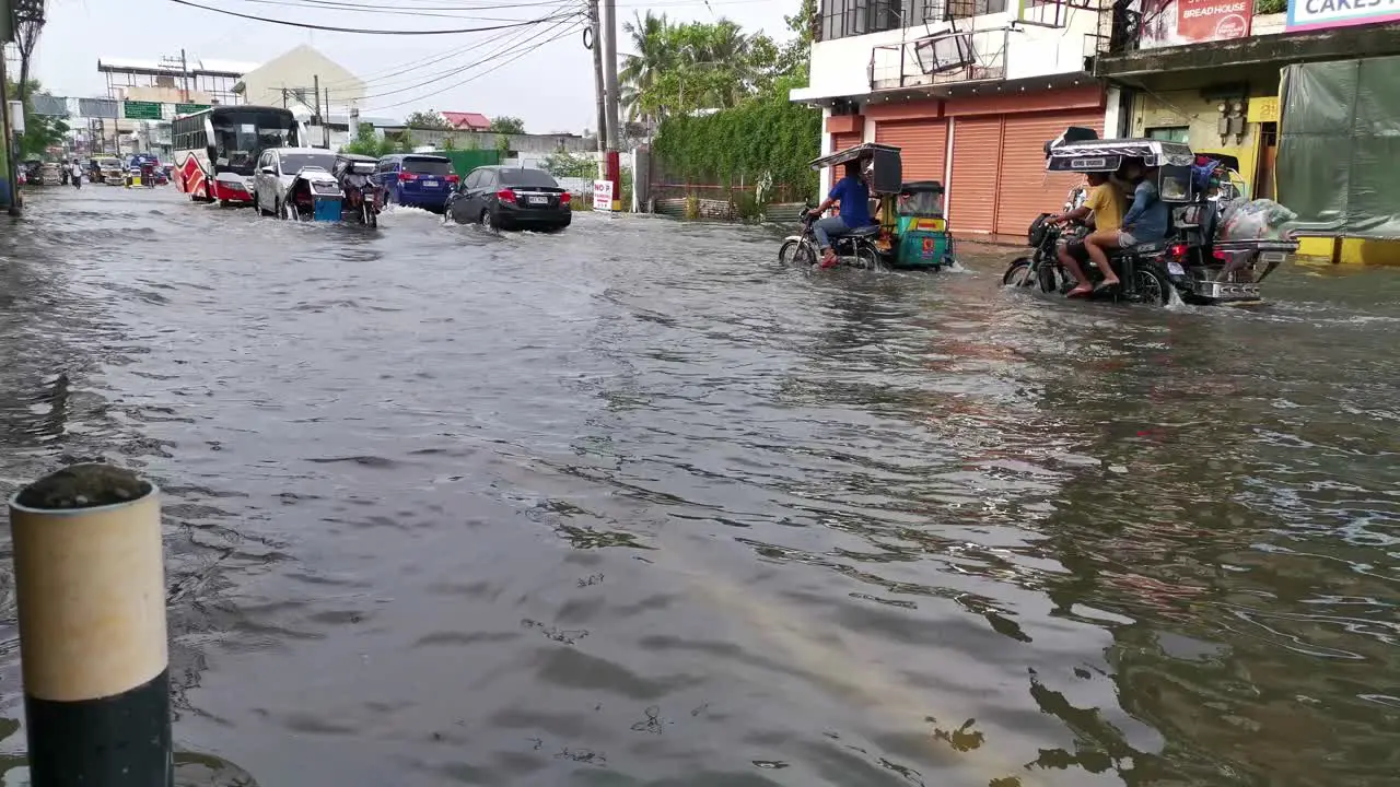 Flooded highway after tropical storm on Dagupan City commuters car and public vehicle slowly driving through submerged roadway