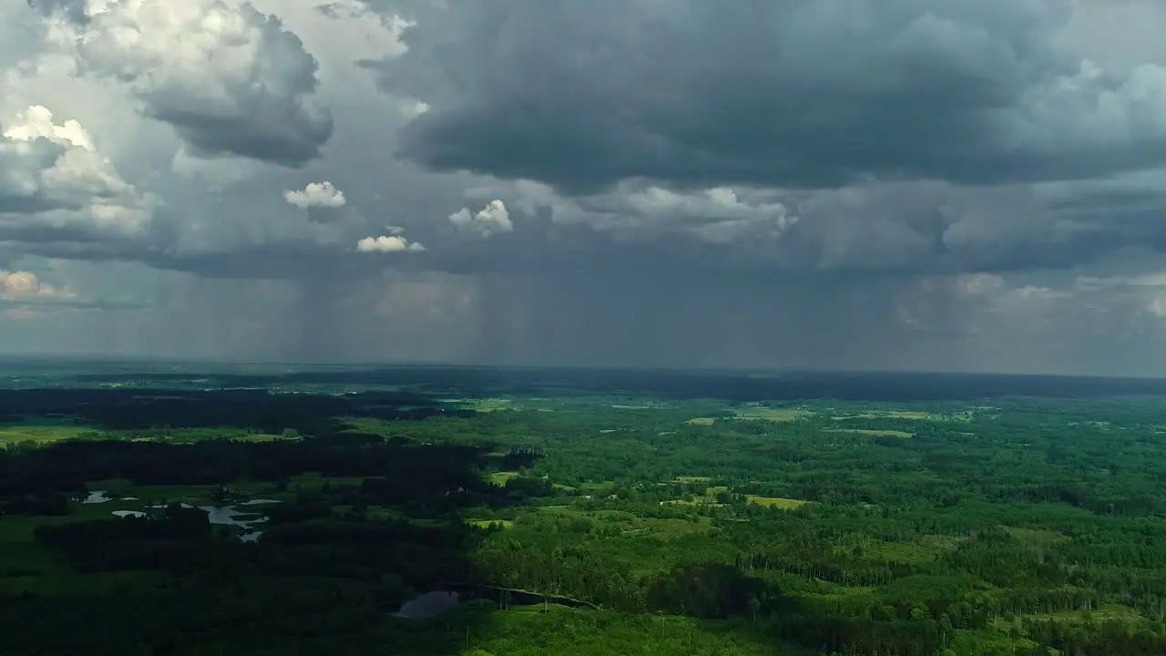 Aerial view of a lush landscape under the dramatic sky of an approaching storm