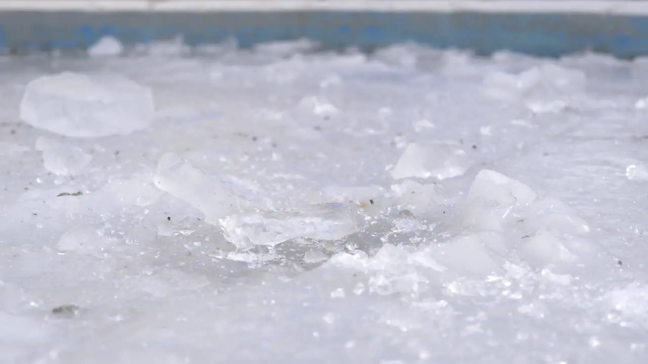 breaking a big block of ice on a frozen fountine of ice