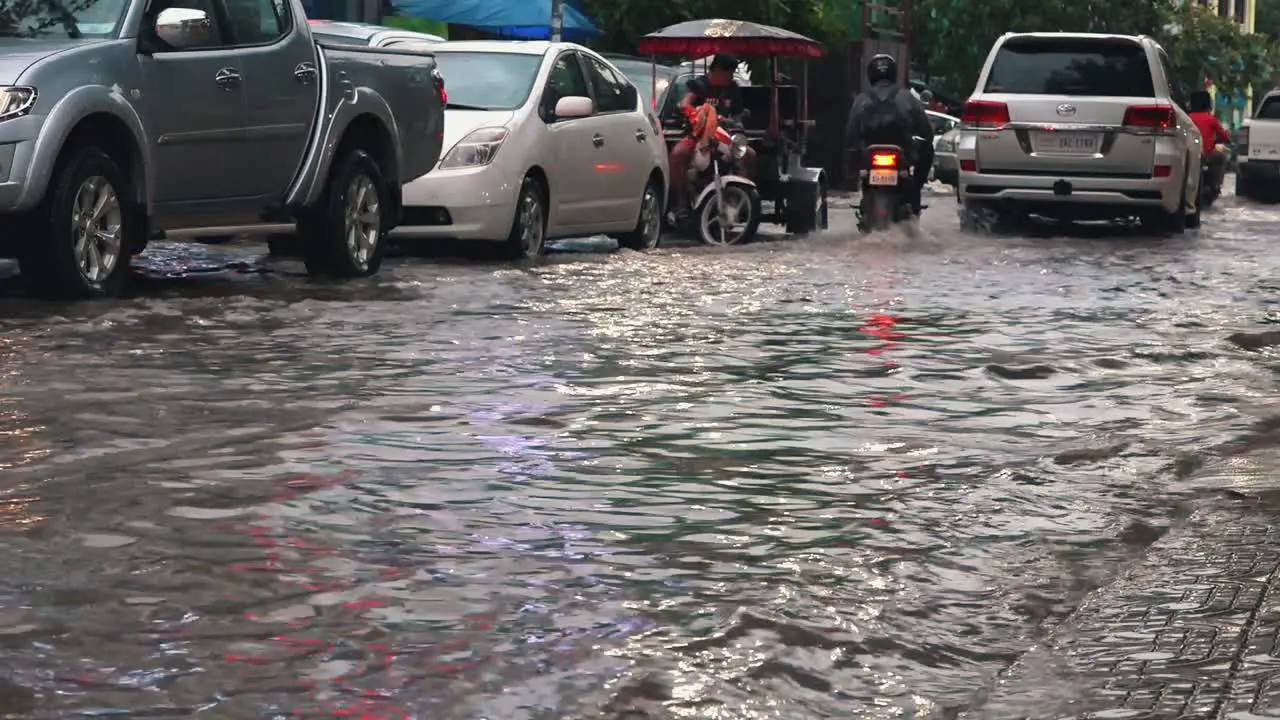 Tuk Tuk Spraying Water as it Drives Through Flooded Streets