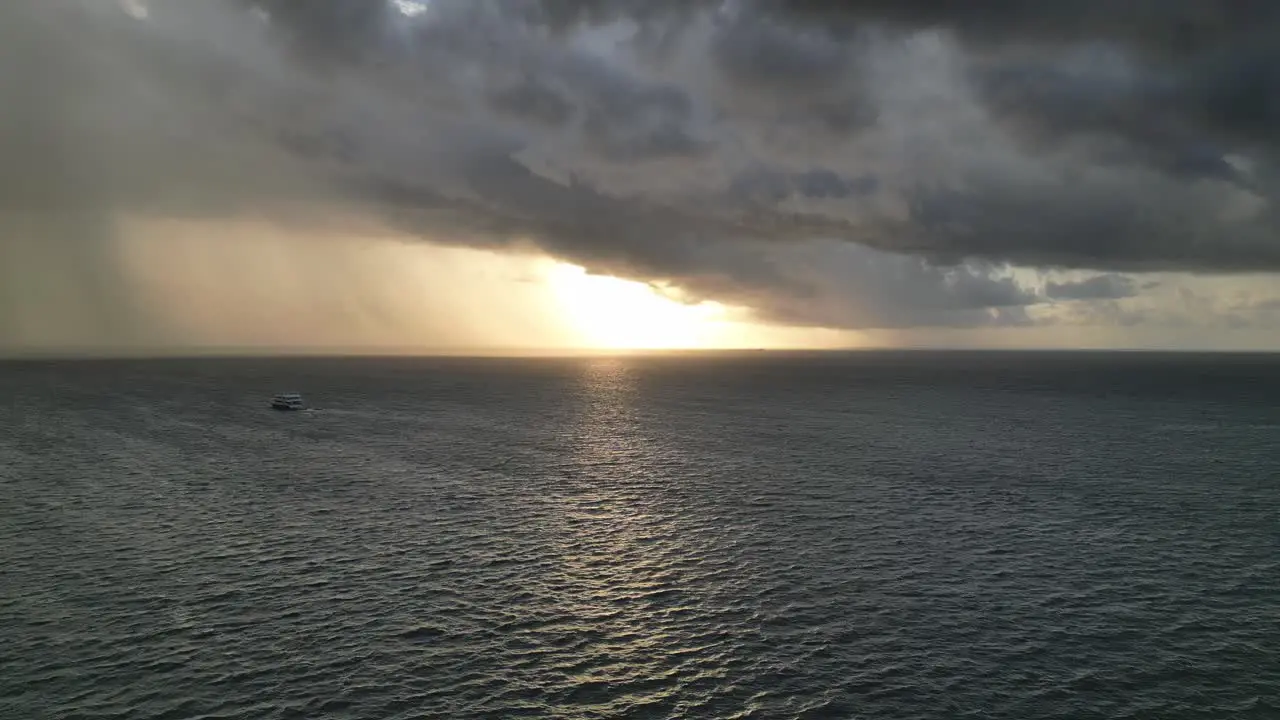 Ferry boat sailing at sunset on calm sea with imminent Storm in Horizon Aerial