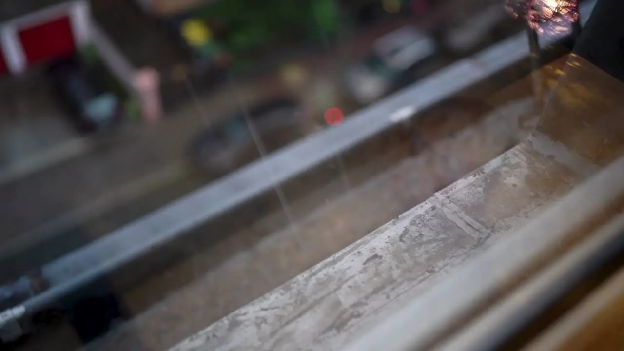 Raindrops on window with blurred street scene below reflective mood overcast day