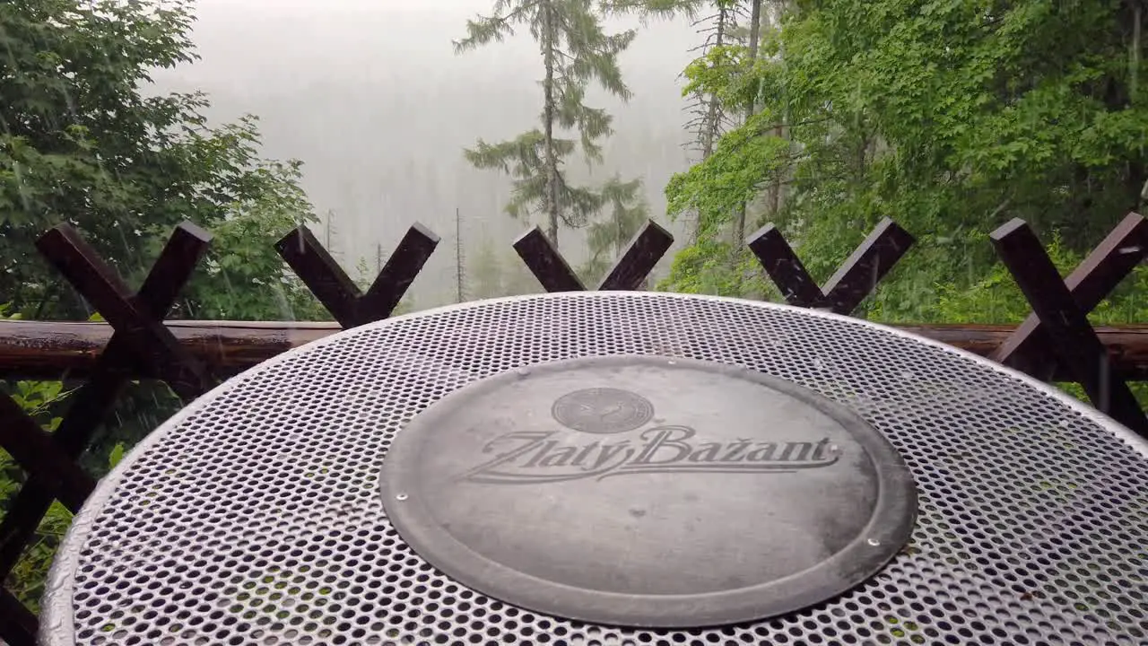 Hail falling on a beer table in mountain bar with forest background