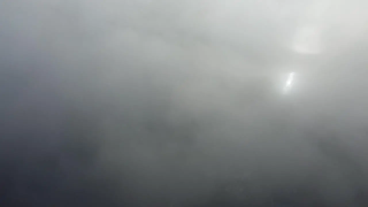 Eerie clouds over a countryside road surrounded by a blinding mist