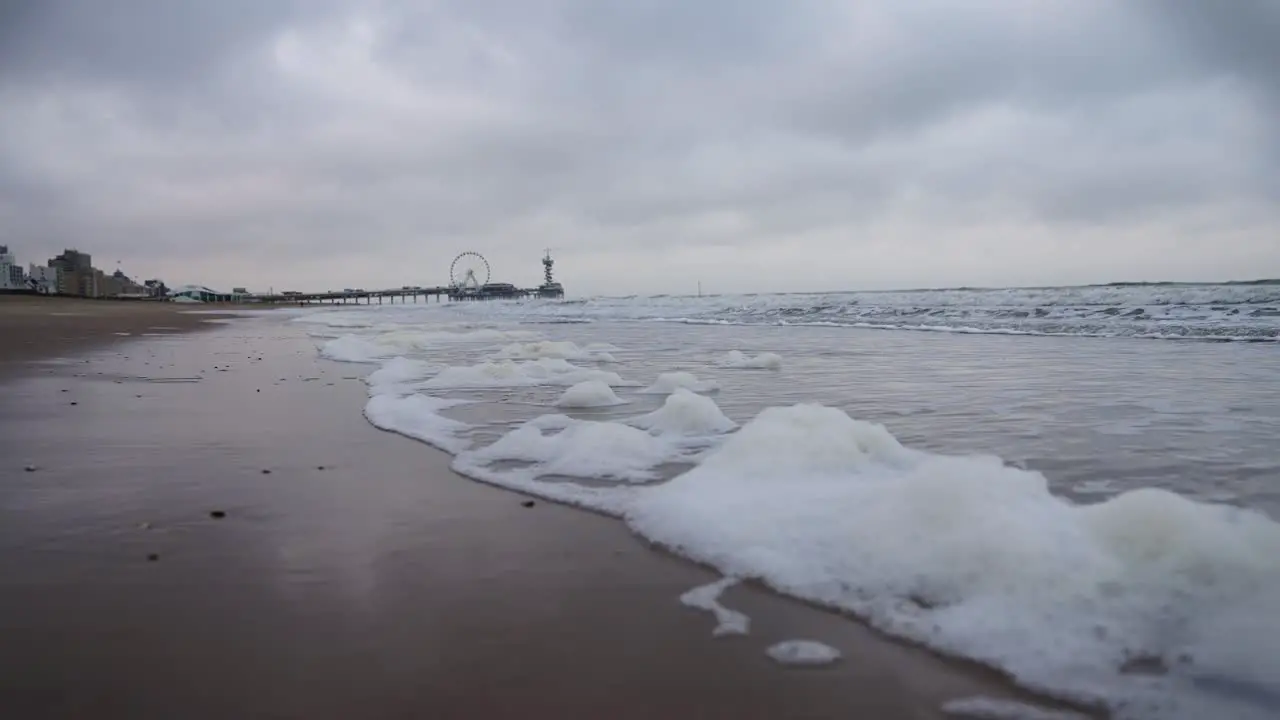 Slow Motion at Scheveningen Beach The Netherlands during Cloudy Weather and Small Foam Wave