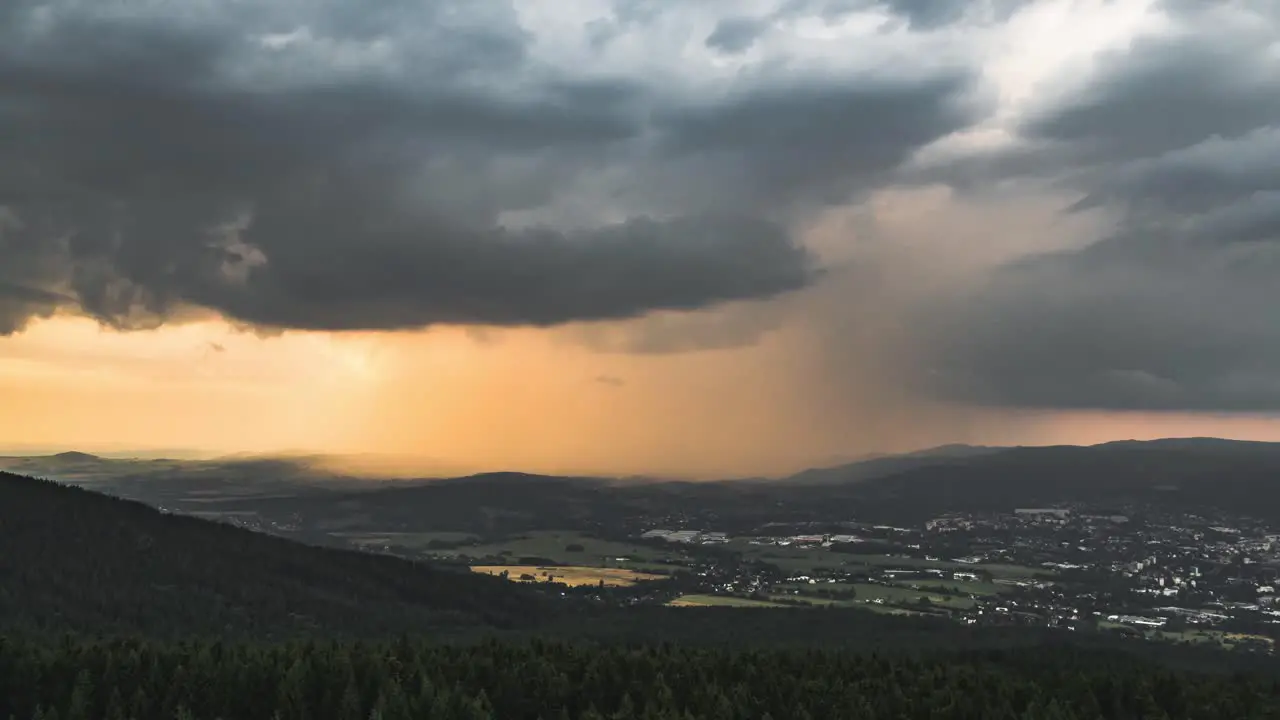 Timelapse of dark and orange storm clouds before sunset zoom view