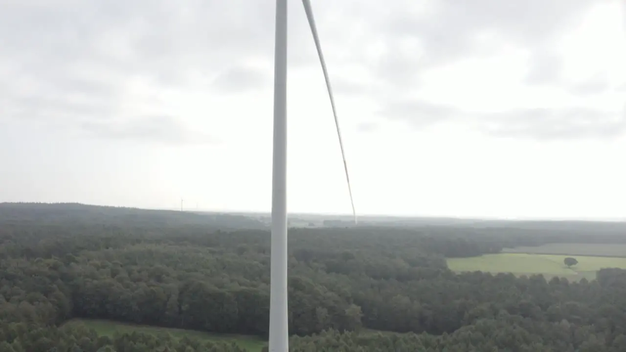 A tilt drone shot of a wind turbine