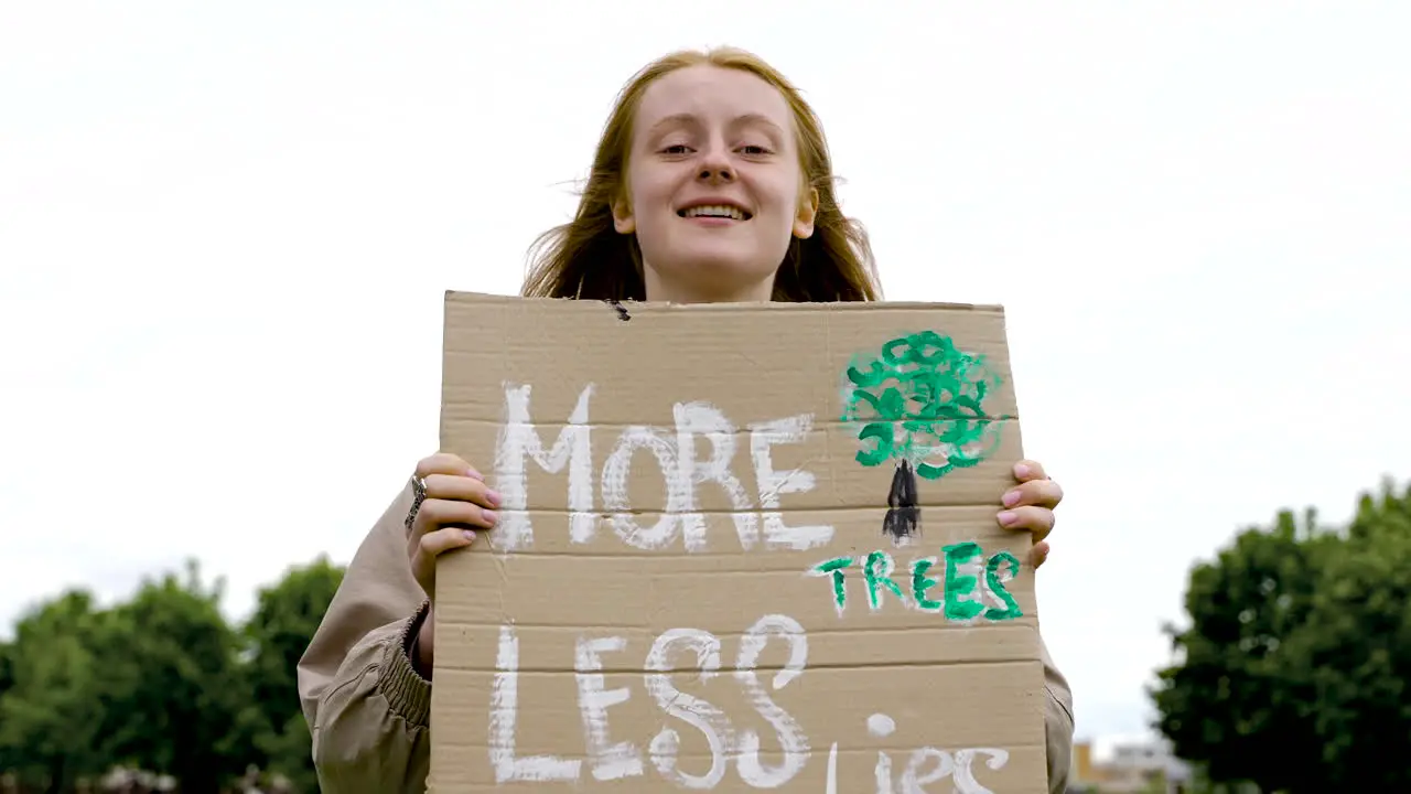 Close Up Of A Redhead Woman Holding A Placard And Talking