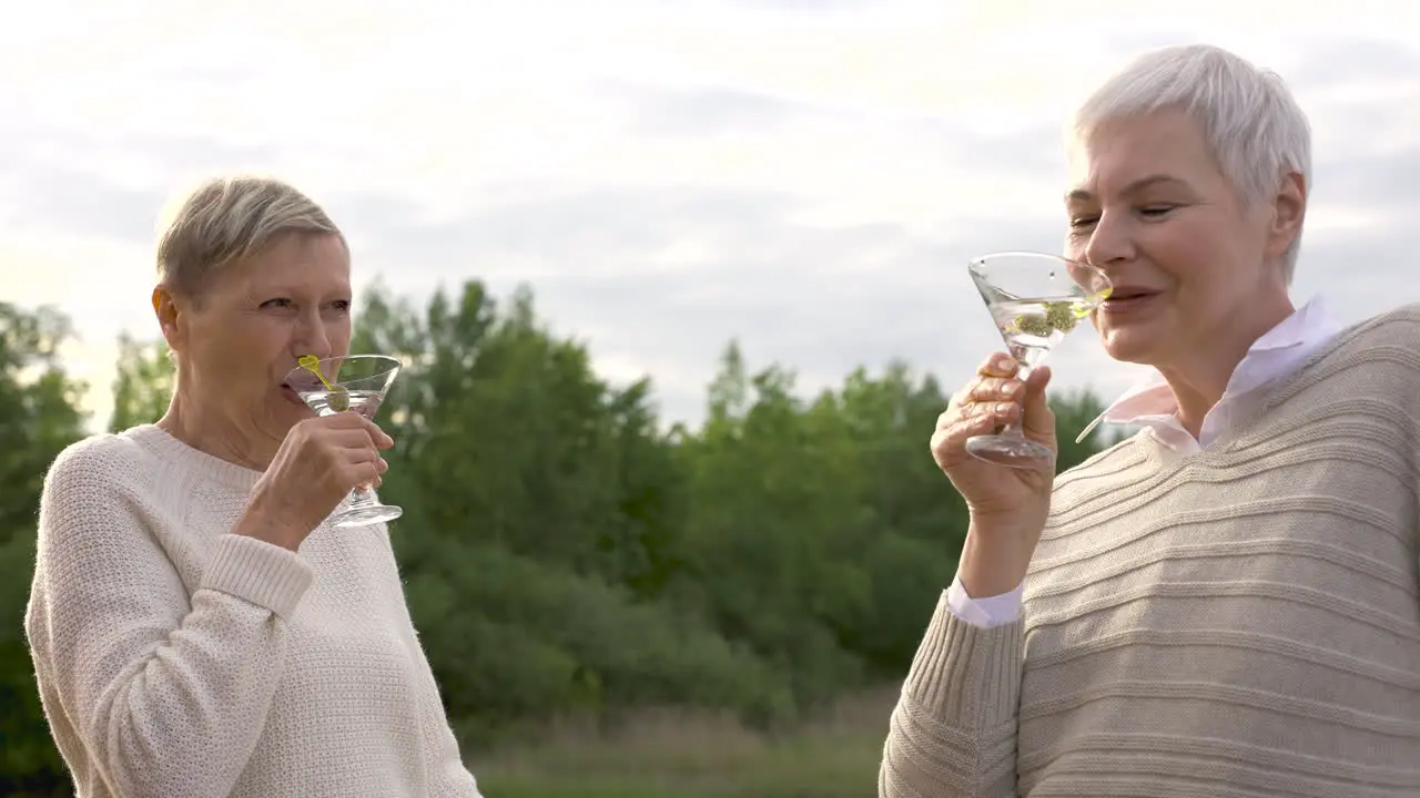 Two Women Talking And Having A Drink Outdoors 1