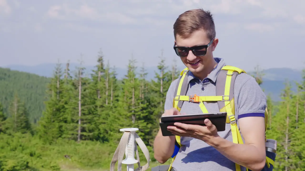 A Man On A Hike Uses A Tablet