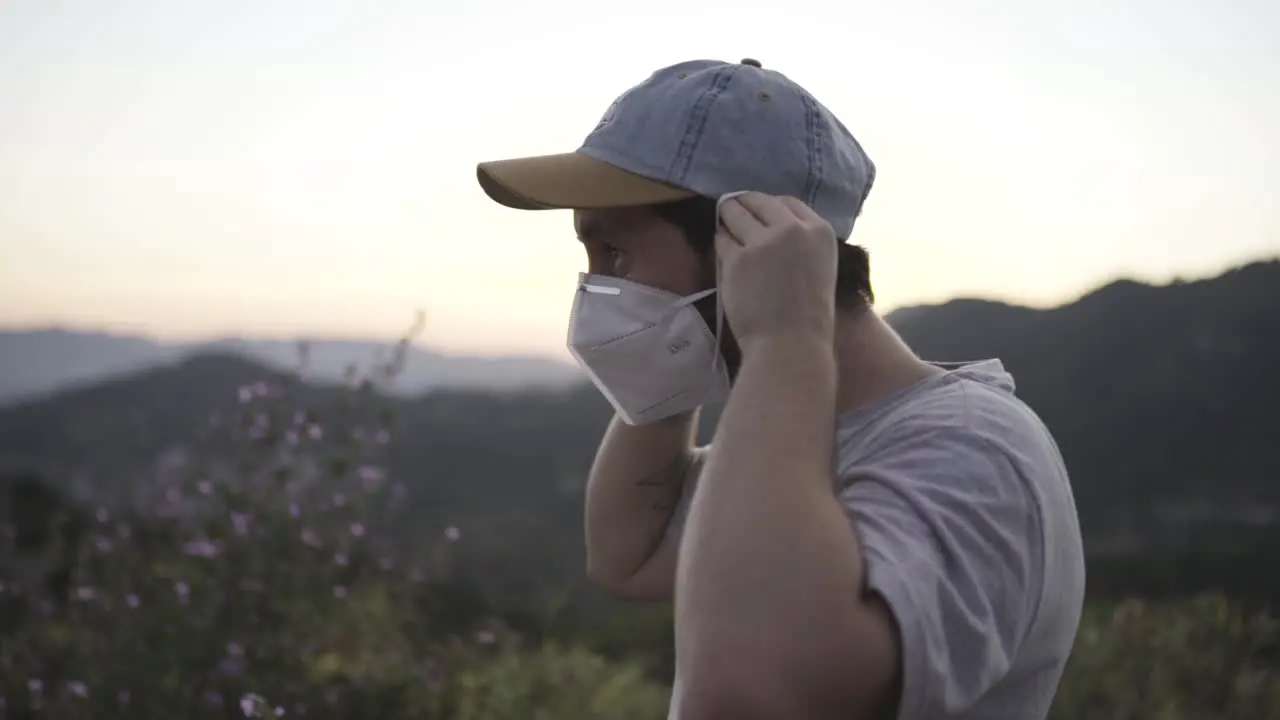 Slow motion young man wearing a mask nature background sunset static shot