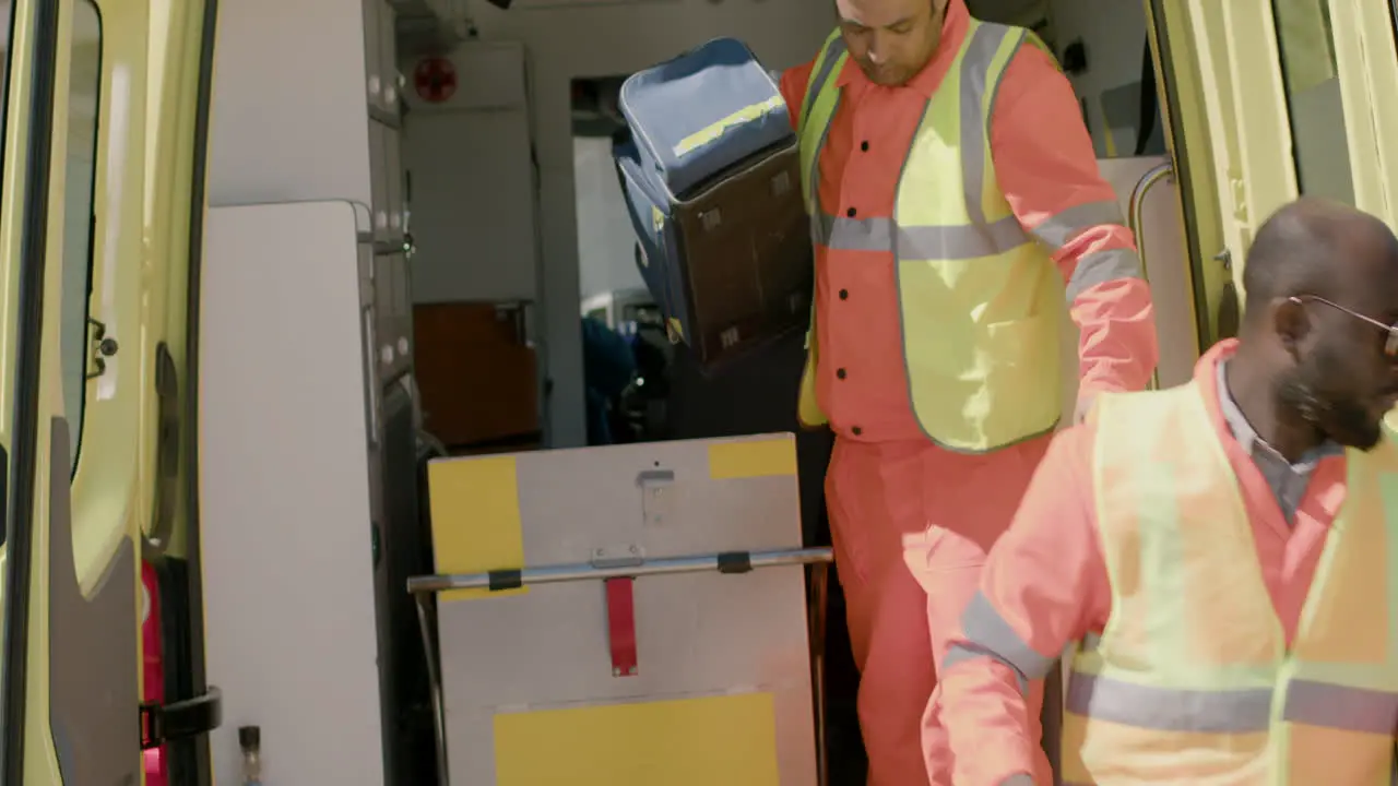 Two Paramedics Opening The Doors Of The Ambulance And Taking Medical Equipment To Attend A Emergency