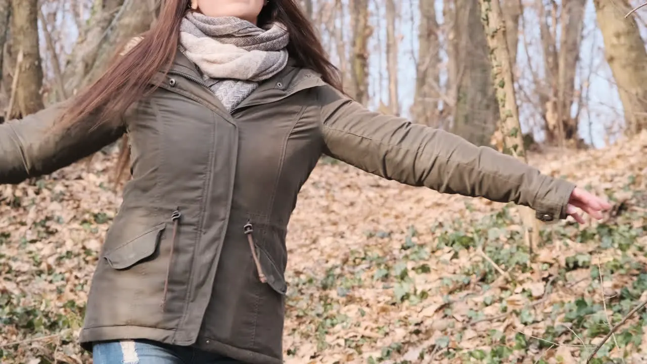 Woman With Brown Hair Dancing In The Middle Of The Forest On A Beautiful Sunny Day Of Winter medium shot slow motion