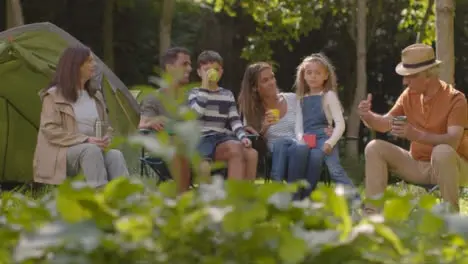 Long Shot of Family On Camping Trip as Grandad Talks to Them