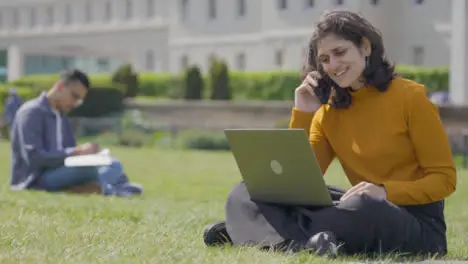 Mid Shot of Female Student Answering Phone in College Park