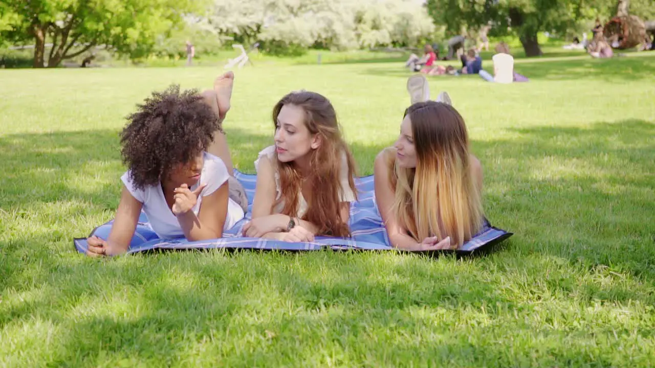 Happy female friends lying on grass