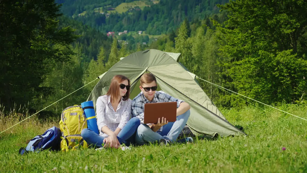 Young People Are Resting In The Campsite And They Use Laptops 1