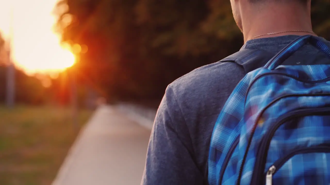 A Teenager With A Backpack Is Walking Along The Road To School Only His Shoulder And Part Of The Bac