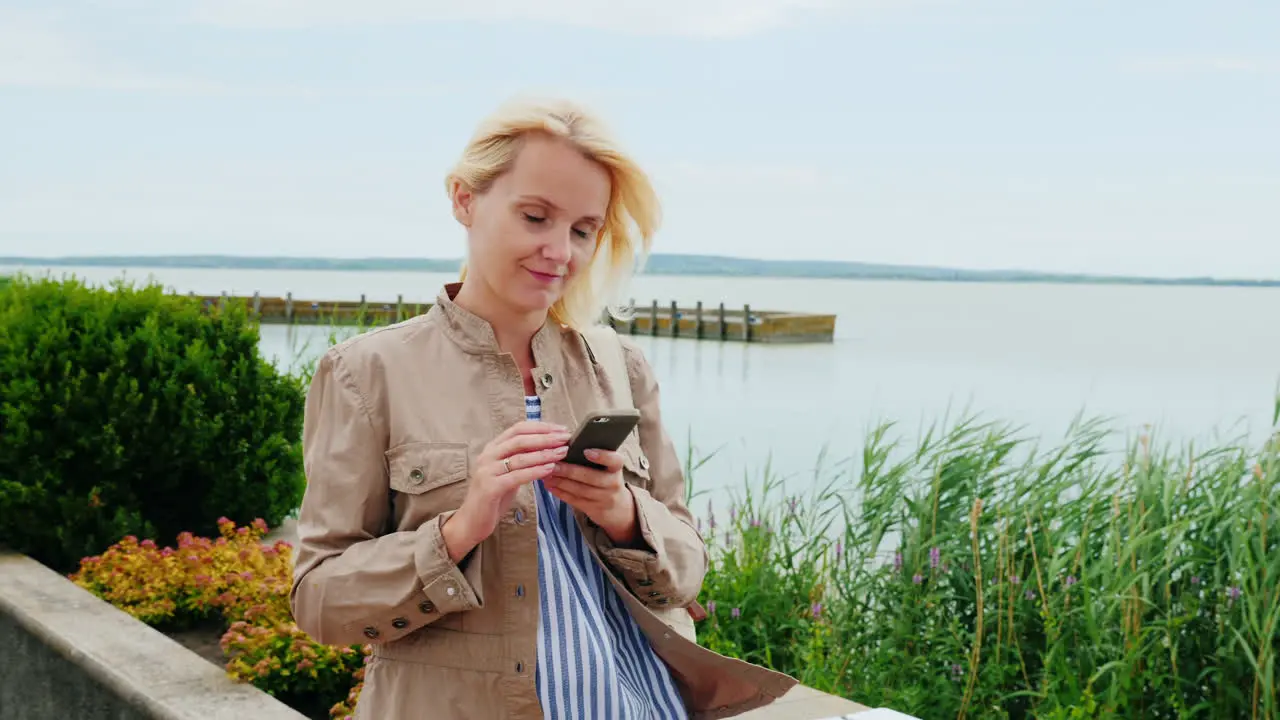 Woman Walking Around Lake Using Phone