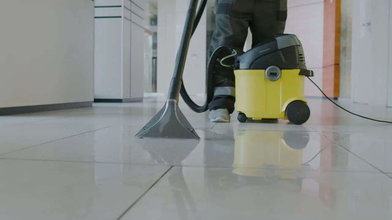 Camera Focuses A Pressure Water Machine That Is Using A Cleaning Man Inside An Office Building