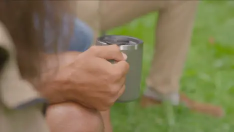 Over the Shoulder Shot of Hand Holding Cup On Camping Trip