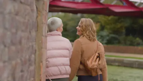 Tracking Shot of Two Young Women Walking by Canal