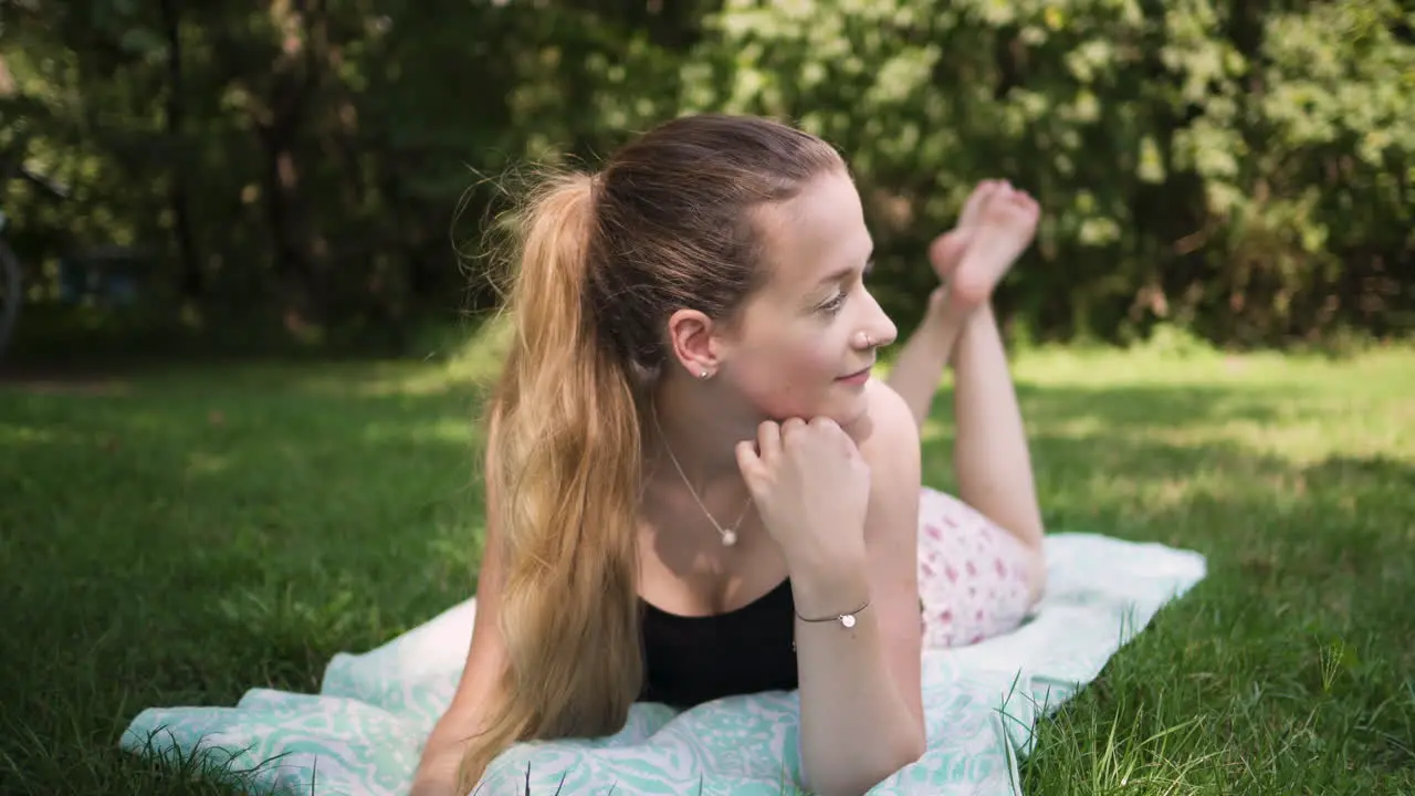 Attractive woman laying in a grassy field enjoying nature