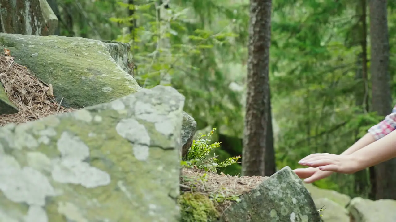 A Woman Climbs A Steep Rock She Is Given A Helping Hand